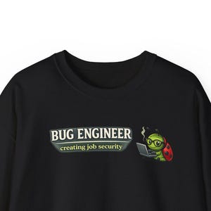 May include: Black sweatshirt featuring the text "BUG ENGINEER creating job security" in white and green. A cartoon ladybug wearing glasses and a red cape is working on a laptop. The sweatshirt has a crew neck.