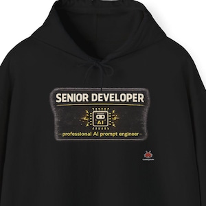 May include: Black hooded sweatshirt with a front pocket and drawstring. The front features a rectangular design with the words "SENIOR DEVELOPER" above a graphic of a circuit board with the letters "AI" and the text "- professional AI prompt engineer -."