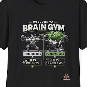 Op de afbeelding: Zwart T-shirt met een afbeelding met de tekst "WELCOME TO BRAIN GYM". Het ontwerp toont een gewichtheffer en een hersen die gewichten en problemen optillen. De tekst onder de afbeeldingen luidt "BODYBUILDER LIFTS WEIGHTS" en "PROGRAMMER LIFTS PROBLEMS".