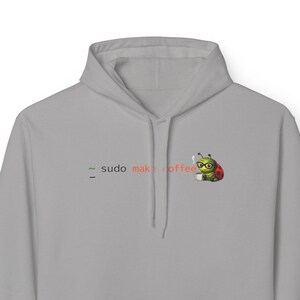 May include: A light gray hoodie with a front pocket and a hood. The hoodie features the text "sudo make coffee" in green and orange, along with a cartoon ladybug wearing glasses and holding a coffee cup.