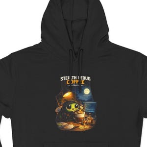 Può includere: Felpa con cappuccio nera con una grafica di un personaggio dei cartoni animati che beve caffè, con la scritta "STEALTH BUG COFFEE". Il design presenta una scena al chiaro di luna con una tazza di caffè e libri. La felpa ha una tasca frontale e un cappuccio.