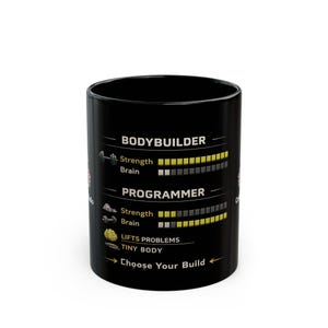 Op de afbeelding: Zwarte keramische mok met de tekst "BODYBUILDER" en "PROGRAMMER" met kracht- en hersenniveau-indicatoren. De mok heeft ook de tekst "Choose Your Build".