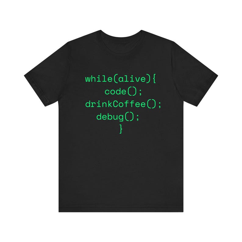 May include: Black t-shirt with green text that reads "while(alive){ code(); drinkCoffee(); debug(); }." The shirt is a crew neck and appears to be made of a soft material. The text is in a monospace font, resembling code.
