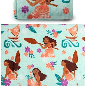 May include: A folded turquoise blanket featuring a repeating pattern of a Polynesian woman with a paddle, flowers, boats, and swirls. The woman is wearing a coral dress. The blanket is soft and plush.
