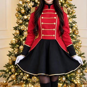May include: A red and black military-style jacket featuring gold braided trim, gold buttons, and gold fringe epaulets, paired with a black flared skirt with gold hem piping, white gloves, and black over-the-knee boots.