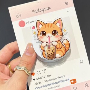 May include: A pink Instagram-themed card featuring a cartoon orange tabby cat drinking bubble tea. The card includes the Instagram logo, a heart, and the text "Album. Thank you for liking it".