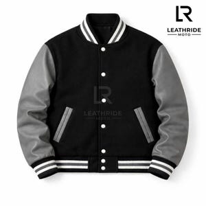 以下が含まれることがあります： グレーの袖が付いた黒のバーシティジャケット。白いスナップボタン式のフロントクロージャー、グレーのトリムが付いた2つのサイドポケット、ストライプ柄のリブ編みの袖口と裾が特徴です。胸元にはLeathride Motoのロゴが配置されています。