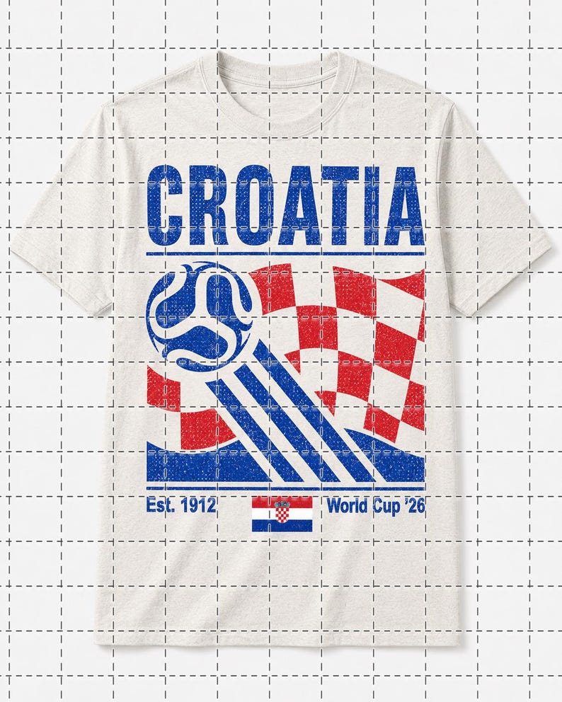 K&ouml;nnte beinhalten: Ein hellbeiges T-Shirt mit dem Wort CROATIA in blauer Schrift. Darunter zeigt eine Grafik einen blauen Fu&szlig;ball mit Bewegungslinien, eine rot-wei&szlig; karierte Flagge sowie den Text Est. 1912 und World Cup '26 neben einer kleinen kroatischen Flagge.