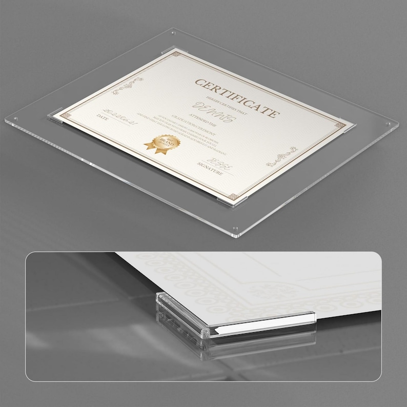 May include: A clear acrylic certificate frame with a gold-toned certificate inside. The certificate has decorative borders and the word "CERTIFICATE" at the top. The frame is square with rounded corners.
