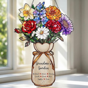 May include: A stained glass floral arrangement in a vase, suspended by a chain. The bouquet features red roses, daisies, and orange, purple, and blue flowers. The vase has a bow and the words "Grandma's Garden" with names.