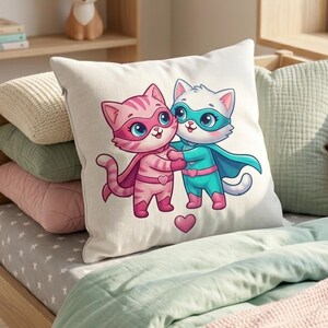 Pode incluir: Uma almofada quadrada branca com uma ilustra&ccedil;&atilde;o de desenho animado de dois gatos super-her&oacute;is abra&ccedil;ando-se. Um gato &eacute; rosa, o outro azul, ambos usando capas e m&aacute;scaras. Um cora&ccedil;&atilde;o rosa est&aacute; abaixo. A almofada est&aacute; em uma cama.