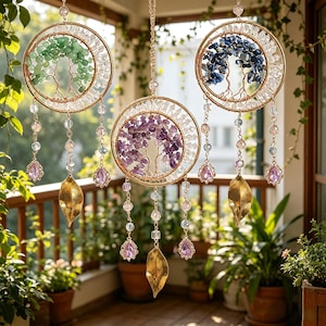 Puede incluir: Tres adornos colgantes decorativos con un diseño de árbol de la vida. Cada uno presenta un marco de alambre dorado, lleno de piedras preciosas verdes, moradas y azules. Cuelgan de cadenas doradas y tienen cuentas de cristal colgantes y detalles de hojas doradas.