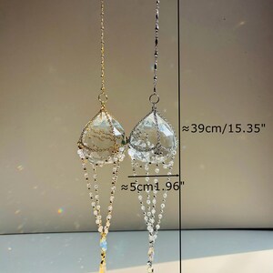 Puede incluir: Dos atrapasoles de prisma de cristal colgando de cadenas doradas y plateadas. Cada prisma mide aproximadamente 39 cm de largo y 5 cm de ancho. El peso de cada atrapasol es de aproximadamente 185 g.