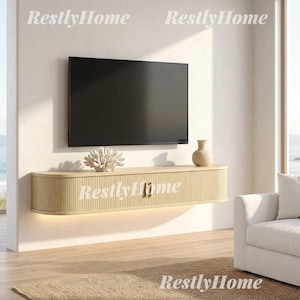 May include: A light beige, wall-mounted floating media console with a rounded, fluted texture design and two central cabinet doors. A flat-screen television is mounted above the console, which is accented by a white coral sculpture and a vase.