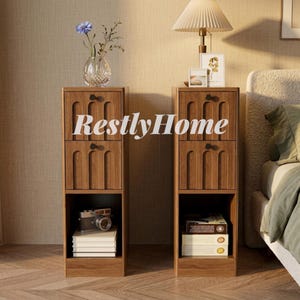 May include: Two tall, narrow wooden nightstands with a medium brown wood grain finish. Each unit features two drawers with arched vertical panel detailing and small round black knobs, plus an open bottom shelf for storage and display.