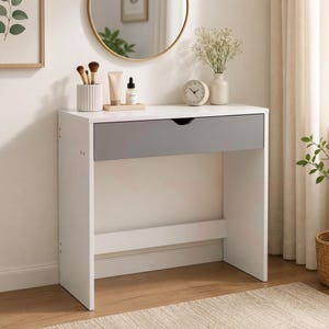 May include: A white vanity desk with a grey drawer. The desk has a minimalist design and is topped with a round mirror, a vase of flowers, a clock, and beauty products. The desk is 102 cm wide and 76 cm tall.