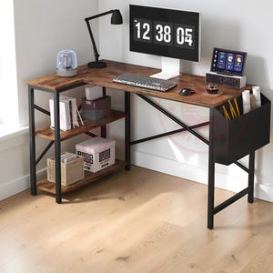 May include: An L-shaped desk with a rustic brown wood-grain surface and a black metal frame. It features three open storage shelves on the left side, a cross-brace support structure, and a black fabric storage pocket attached to the right side.