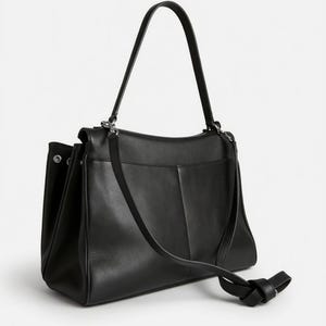 Pu&ograve; includere: Una borsa in pelle nera con tracolla e manico superiore. La borsa ha una forma rettangolare con una tasca frontale e un dettaglio annodato sul cinturino. La borsa &egrave; realizzata in pelle liscia e ha un design minimalista.