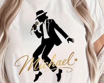 May include: White t-shirt featuring a black silhouette of a singer in a suit and hat, holding a microphone. The name "Michael" is written in gold script below the figure, with a star accent.