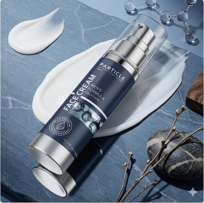 May include: A silver and navy blue face cream bottle with the text "FACE CREAM" and "MEN'S FORMULA DAILY CARE". The bottle is 1.7 fl oz / 50ml. White cream is spread on a blue surface.
