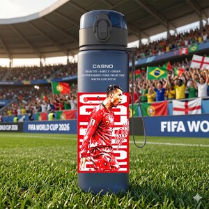 May include: A navy blue water bottle featuring a soccer player in a red uniform. The bottle has a black cap and a strap. Text on the bottle reads "CASNO" and "HEALTHY - SAFELY - GREEN - OUTSTANDING COME FROM THE WATER LIFE STYLE."