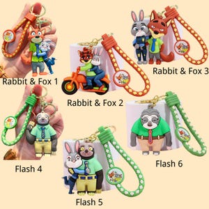 May include: Keychains featuring cartoon characters, including a fox and a rabbit, with braided straps in orange and green. Each keychain has a circular charm with character art and text. The keychains are labeled "Rabbit & Fox" and "Flash".