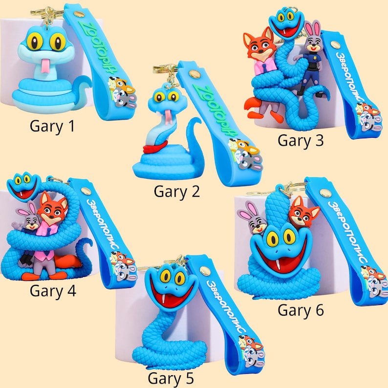 May include: A collection of blue keychains featuring cartoon snake characters with large yellow eyes. Each keychain has a blue strap with the text "Zootopia" and cartoon characters. The keychains are labeled "Gary" followed by a number.