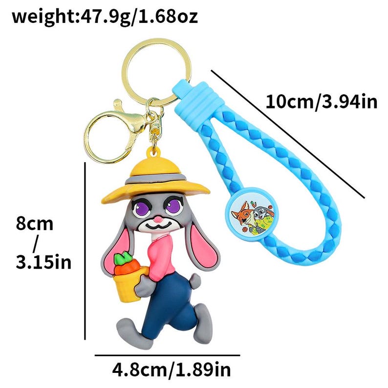 May include: A keychain featuring a cartoon bunny character with a yellow hat, pink shirt, and blue pants, holding a carrot. The keychain has a blue braided strap, a round charm, and a gold-colored keyring. The bunny is 3.15 inches tall.