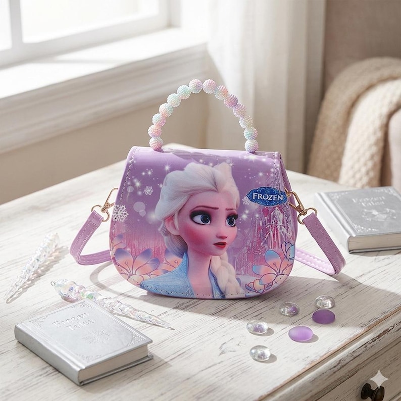 May include: A purple purse featuring Elsa from Frozen, with a beaded handle and a detachable shoulder strap. The purse has a decorative design with a castle and snowflakes. The purse is on a white wooden surface.