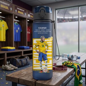 May include: A navy blue water bottle featuring a graphic of a soccer player in a yellow jersey with the number 10. The bottle has a black cap and the text "CASNO" and "HEALTHY. SAFELY. GREEN. OUTSTANDING. COME FROM THE WATER LIFE STYLE."