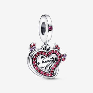 Op de afbeelding: Een zilverkleurige metalen bedel met een hartvormige hanger met duivelshoorntjes. Het hart is omlijnd met kleine rode steentjes en bevat de zwarte tekst 'my heart'. Een enkele rode steen is gezet in het bovenste oogje van de bedel.