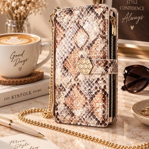 May include: A rectangular wallet with a brown and white snakeskin pattern, featuring a gold-toned metal chain strap and a hexagonal gold clasp. The wallet has a side zipper closure and a structured design, presented as a functional accessory item.