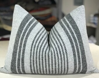 May include: A gray and black striped throw pillow with a soft, textured fabric.