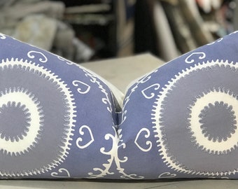 May include: A pair of decorative throw pillows with a blue background and white embroidered designs. The pillows feature a circular pattern with a smaller circle in the center.