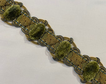 May include: Gold and green trim with a repeating pattern of knotted rope and fuzzy green pom-poms.