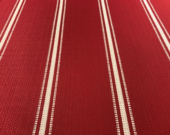 May include: Red fabric with white stripes. The fabric has a woven texture.