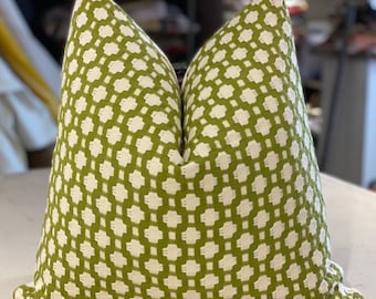 May include: A green and white patterned throw pillow with a geometric design. The pillow is made of a soft, woven fabric.