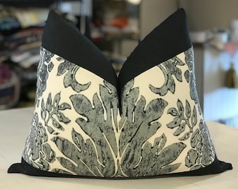 May include: Two decorative throw pillows with a black trim and a white background with a gray floral pattern.