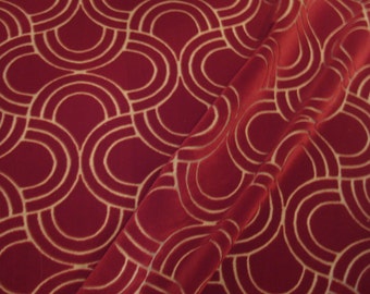 May include: Red fabric with a gold geometric pattern of overlapping circles and arches.