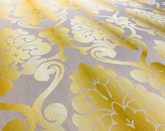 May include: A close-up of a fabric with a damask pattern. The fabric is a light beige color with a gold floral design.