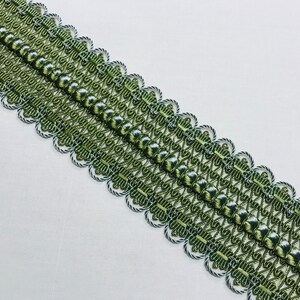 May include: Green and white braided trim with a scalloped edge. The trim has a repeating pattern of small beads and a woven design.