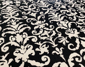 May include: Black and white fabric with a damask pattern. The pattern features swirls and leaves.