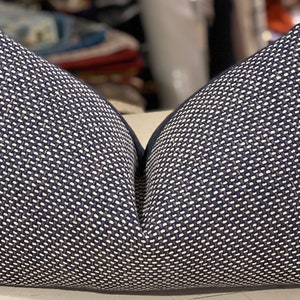 May include: Two navy blue throw pillows with a white geometric pattern. The pillows are made of a woven fabric and have a subtle sheen.