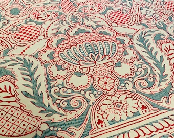 May include: A close-up of a fabric with a repeating pattern of red and blue floral designs. The fabric has a white background and the floral designs are intricate and detailed.