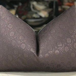 May include: Two decorative throw pillows with a floral pattern in a dark gray color.
