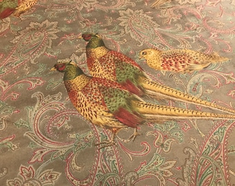 May include: A brown fabric with a paisley pattern featuring three colorful pheasants. The pheasants are depicted in a realistic style with intricate details.