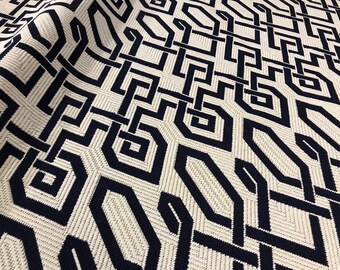 May include: A white fabric with a navy blue geometric pattern. The pattern is made up of interlocking squares and rectangles.