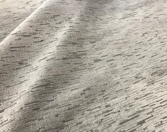 May include: Close-up of a white fabric with a subtle, textured, woven pattern. The fabric has a slightly shimmery finish.