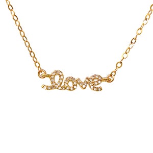 May include: A gold necklace with a cursive 'LOVE' pendant encrusted with small, clear stones.