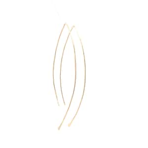 May include: A pair of gold-toned, thin, wire earrings with a curved, elongated shape.